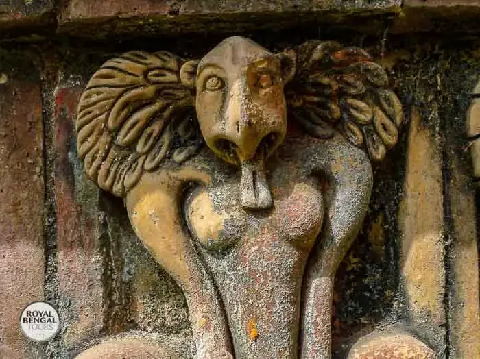 a weathered terracotta plaque depicting a wrathful Buddhist deity on the walls of Somapura Mahavihara