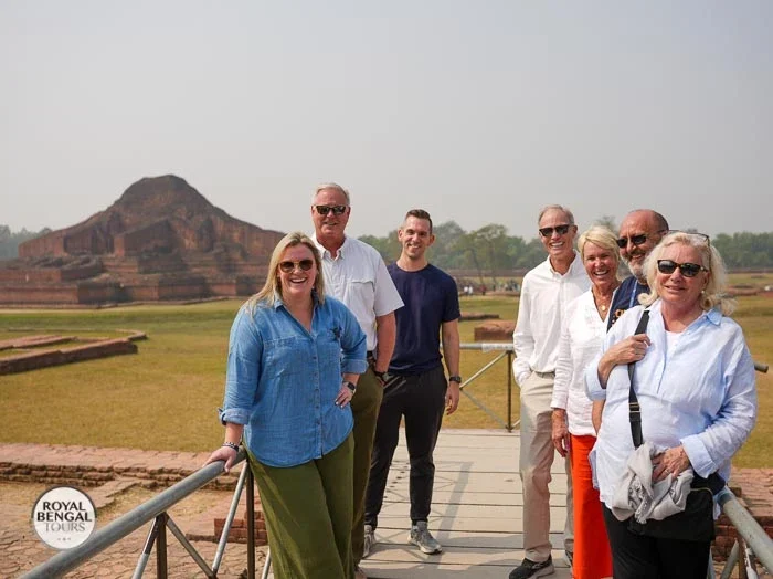 Tourists posing for a photo in front of the Somapura Mahavihara Buddhist monastery