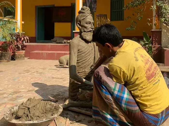 Artisan carefully wraps a wax model with clay to create a mold for lost-wax casting