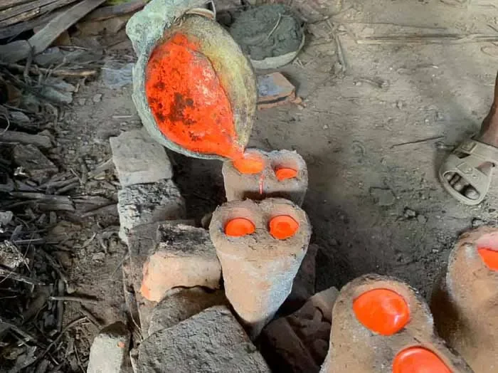 Molten brass poured into intricate clay mold, Bangladesh. Lost-wax technique, glowing metal