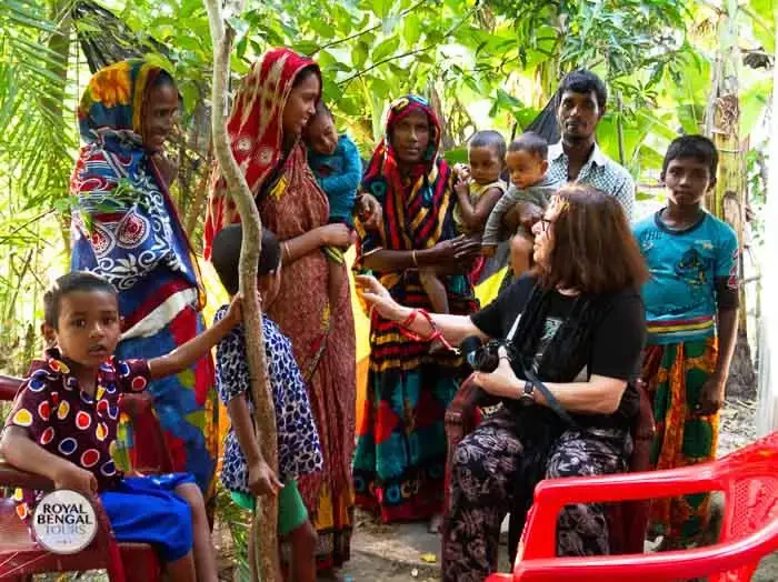 Tourists interact with local Bangladeshi women in a village while on a homestay