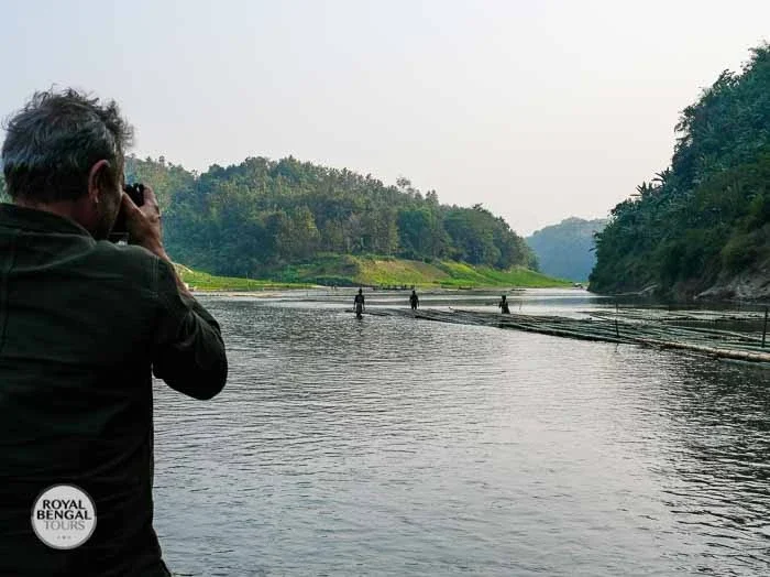 Western photographer taking a picture of the Chittagong Hill Tracts river valley, Bangladesh