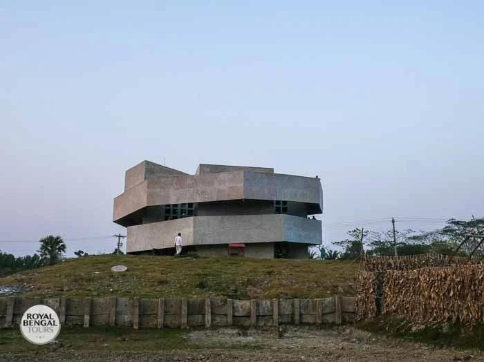 a cylindrical, thatched-roof cyclone shelter on stilts in Kuakata, Bangladesh