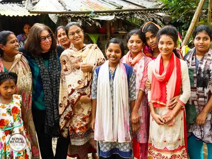 Photo of a Western tourist talking to a Bangladeshi people during floating market trip in Barisal