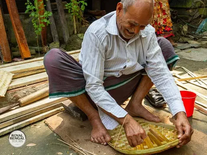 a Bangladeshi craftsman making bamboo handicrafts for sale at the floating market in Barisal