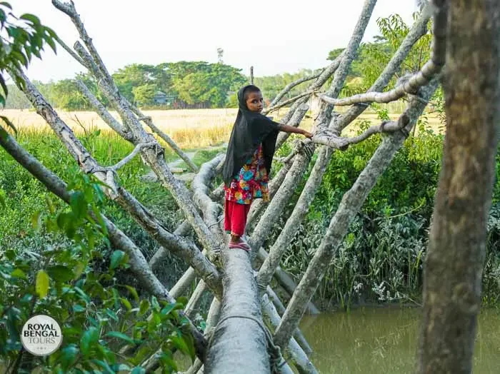 Determined steps A young girl crosses a bridge on her way to school in Nijhum Dwip