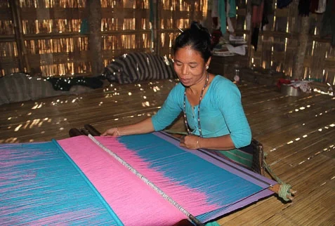 Tripura tribal lady weaving traditional Tipra dress at home textile