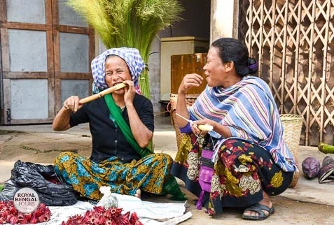 Two tribal women engaged in conversation at a bustling weekly bazaar in Bandarban