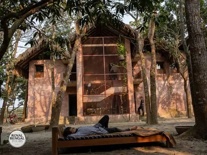 A person relaxing on a bed at Panigram Resort in Jessore