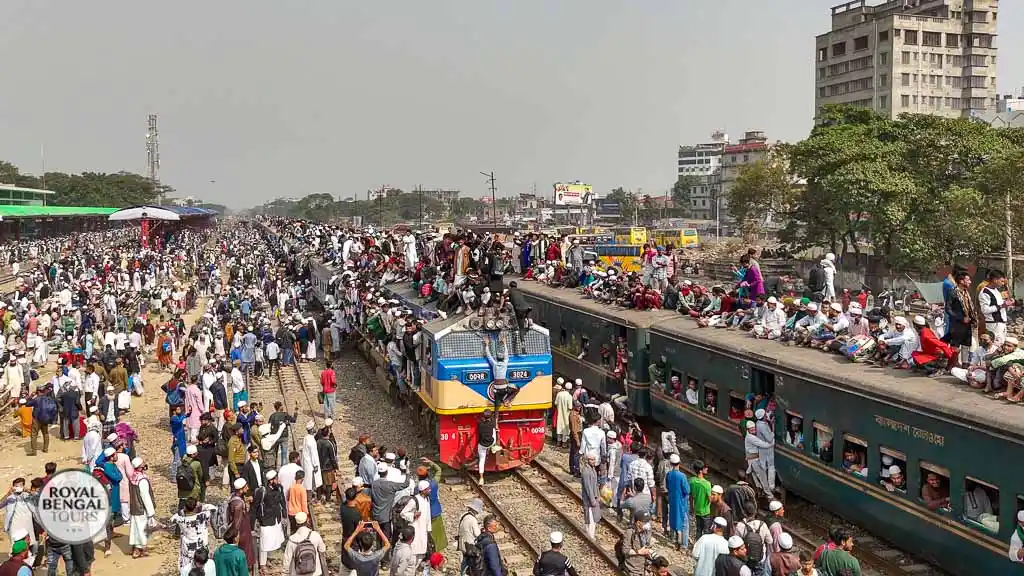 Pilgrims riding on train roof during Ijtema, Bangladesh. Crowded train, religious gathering.